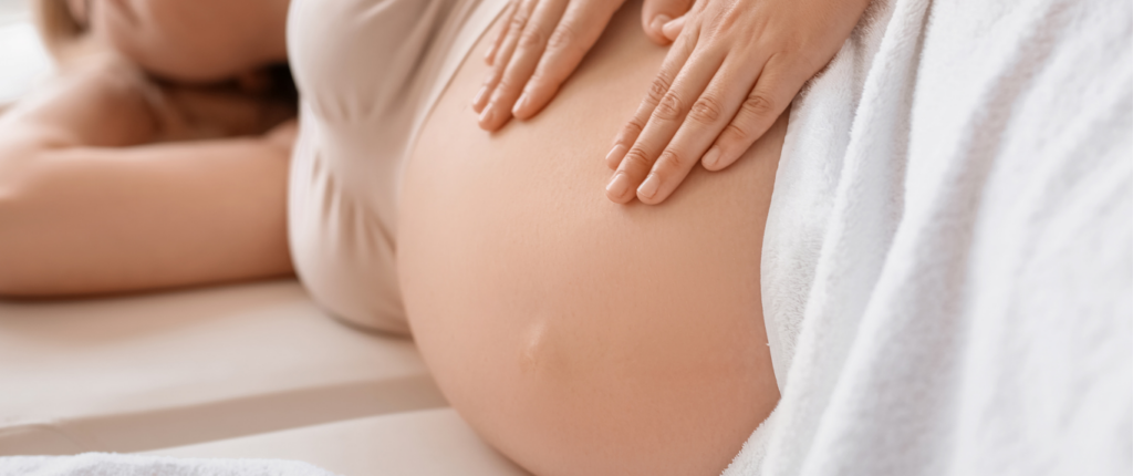 Pregnant woman lying in bed while a doctor performs a medical examination.