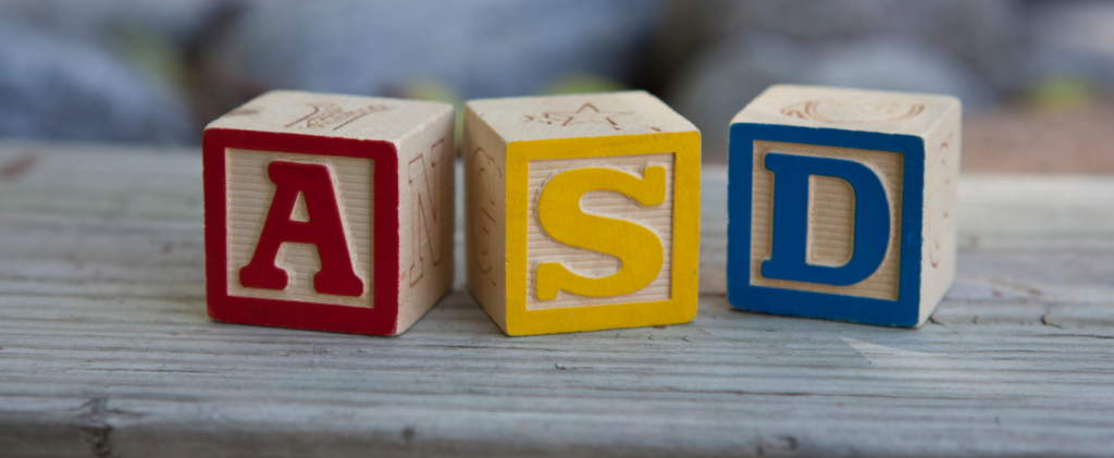 Wooden bricks arranged on a table with the letters 'ASD' written on them.