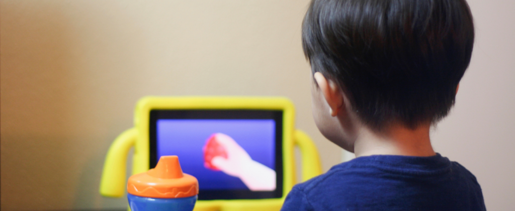 Young child focused on a cartoon playing on a tablet screen