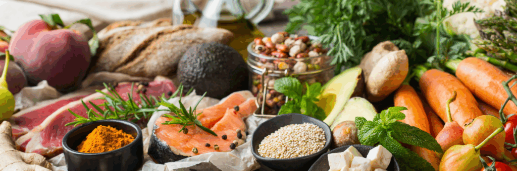Fresh Mediterranean diet ingredients—olive oil, tomatoes, herbs, and fish—arranged on a rustic table